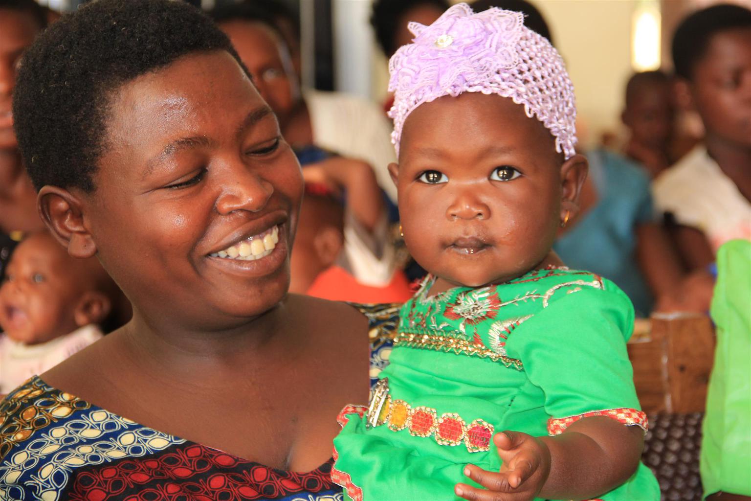 mother-holding-child-tanzania - Nutrition International Photo of a smiling mother holding her daughter in Tanzania