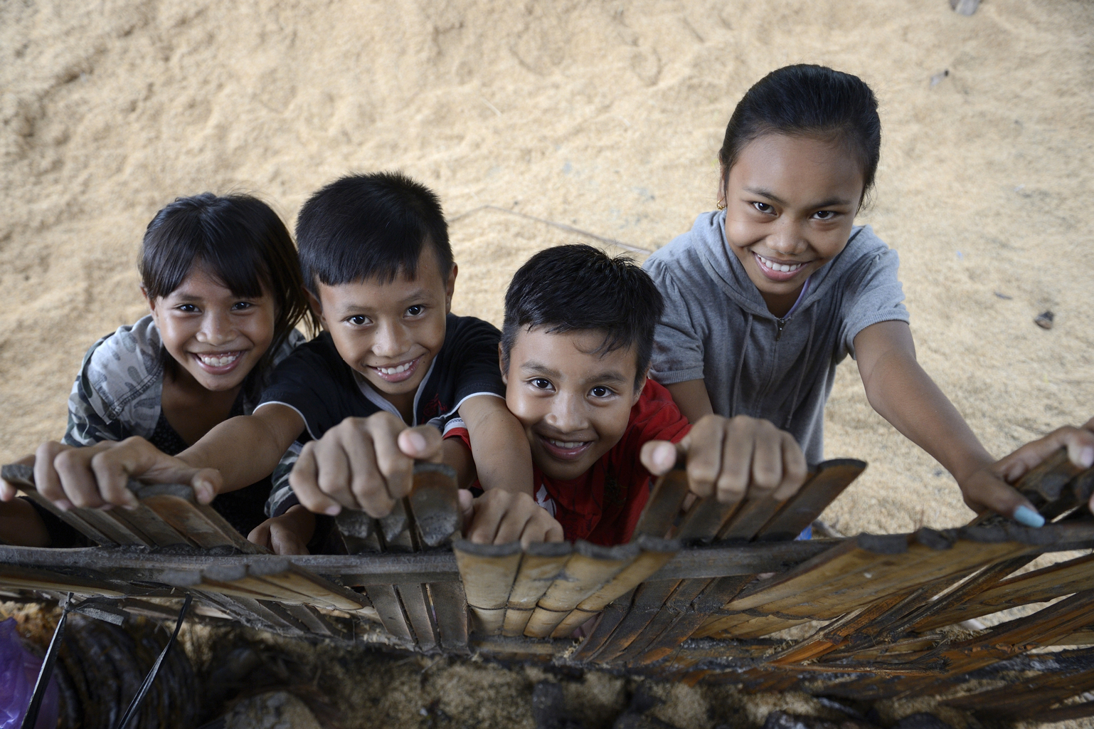 indonesia-girls-boys-smiling - Nutrition International two girls and two boys in Indonesia looking up and smiling