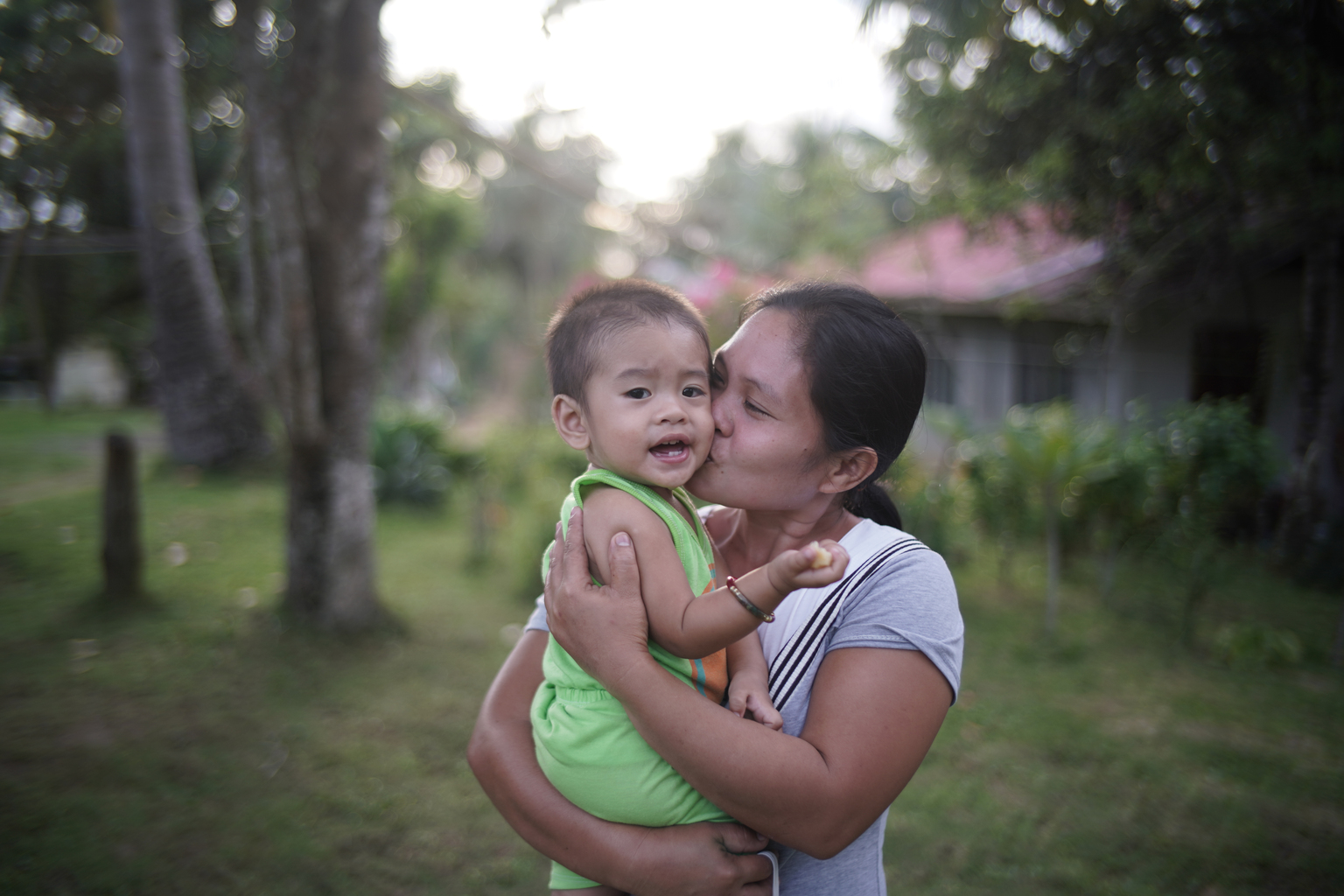 Philippines_BF1KD_JED04020 - Nutrition International Mother kisses her child on the cheek while the child laughs.