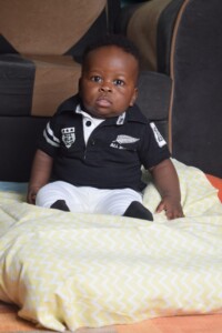 - Nutrition International Baby sitting on a pillow looking at the camera