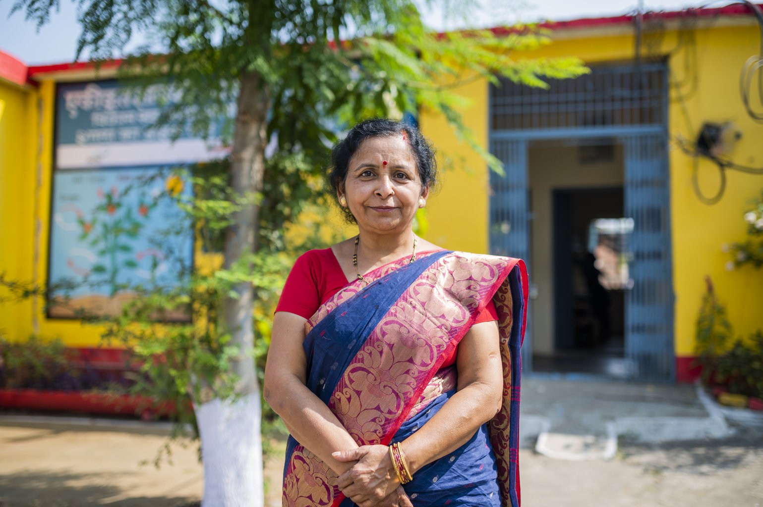 NI MP 2022 - Nutrition International A woman in a red sari faces the camera