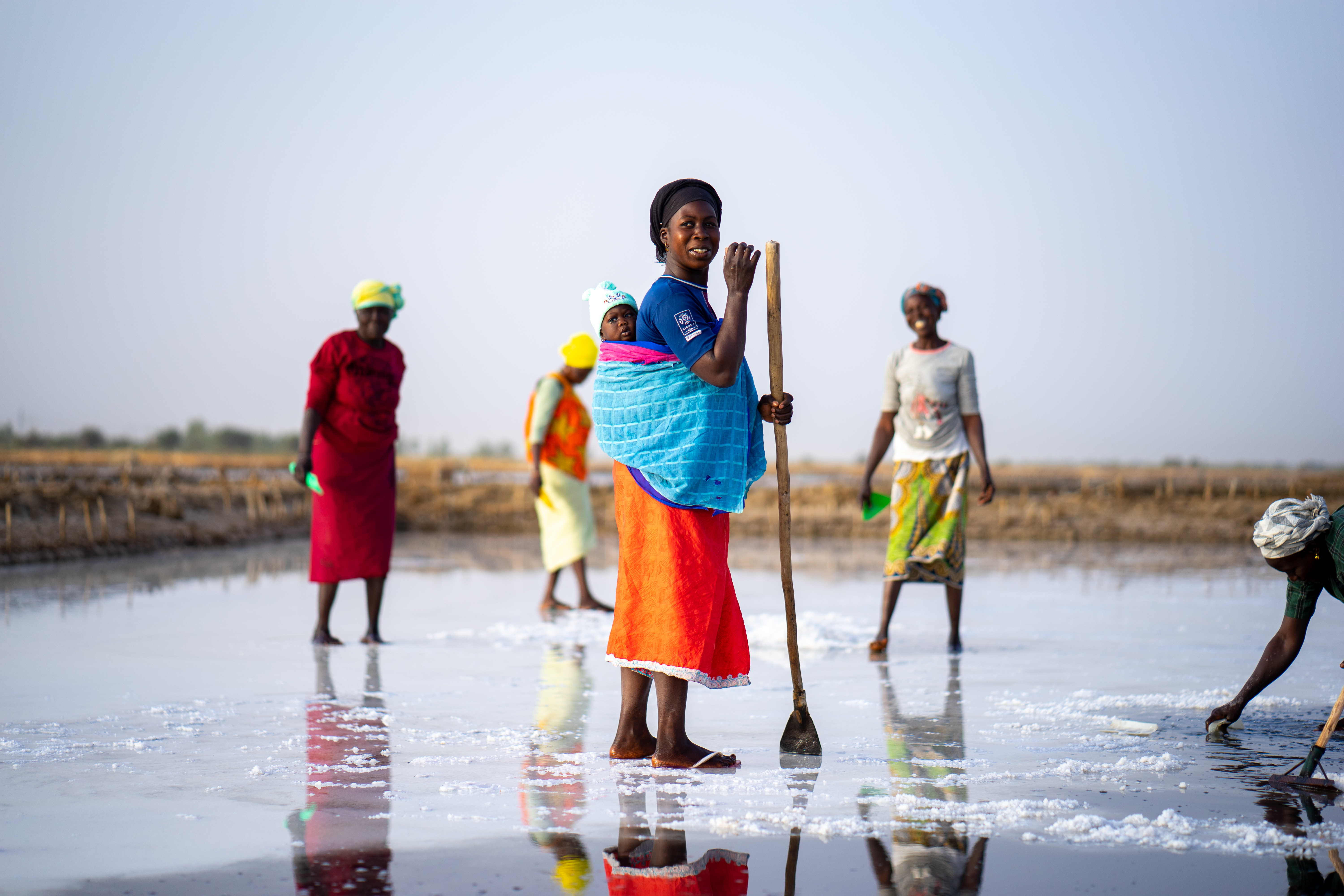 DSC04149 - Nutrition International A woman stands in the middle of a salt field in Senegal.