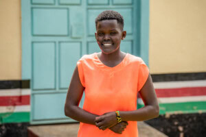 Kenya - Sherry - Nutrition International Sherry, standing and smiling at the camera