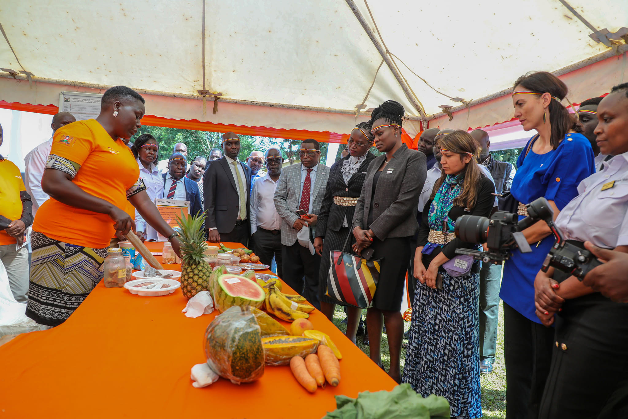 A group of people stand in a front of a table with food on it