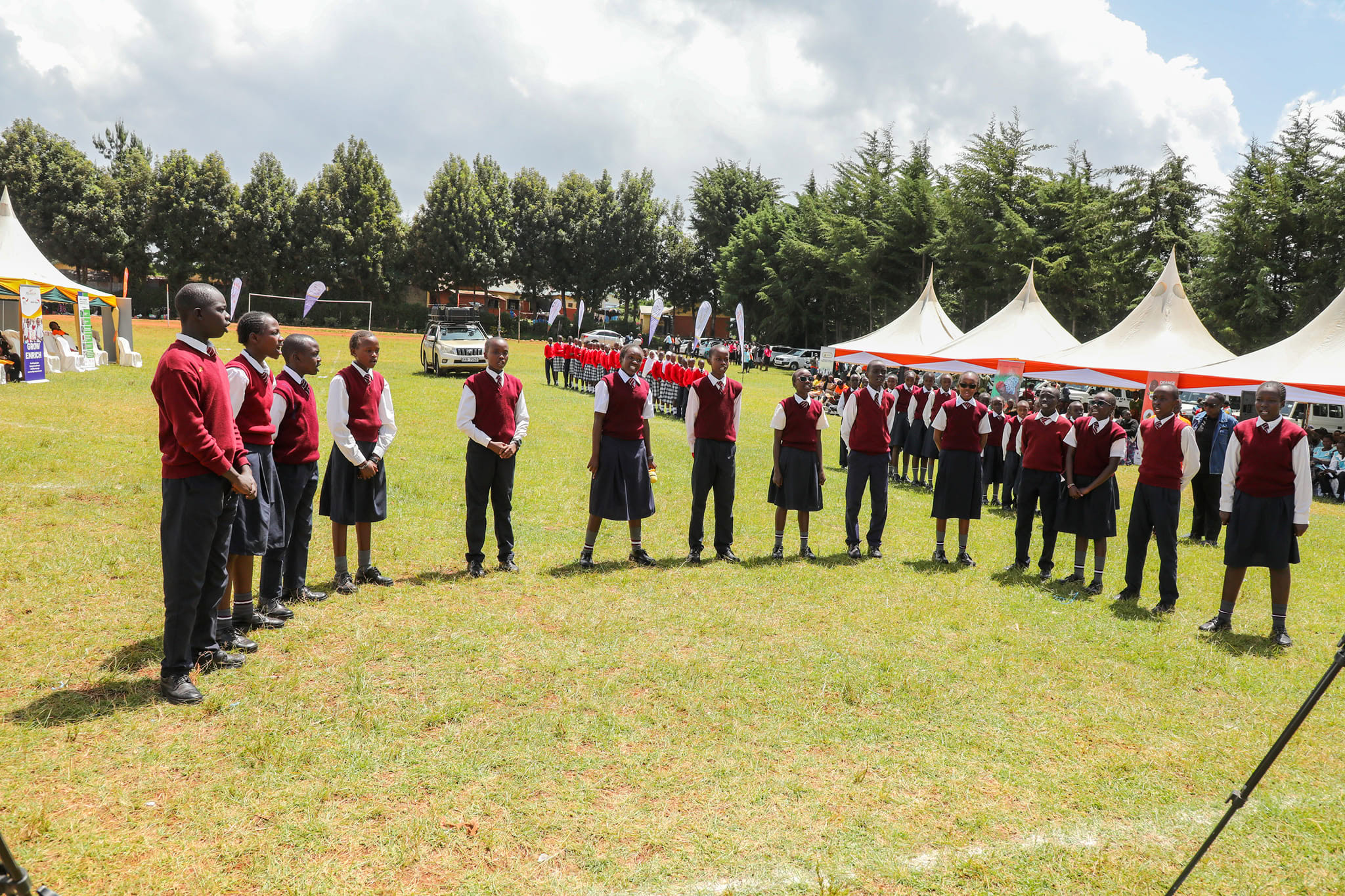 A group of adolescent girls and boys standing in a semi-circle